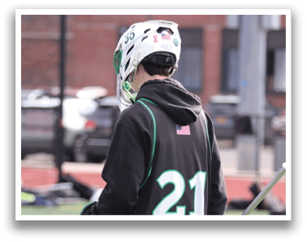 A person wearing a black and green jersey is holding a stick and standing on a field. AI generated content