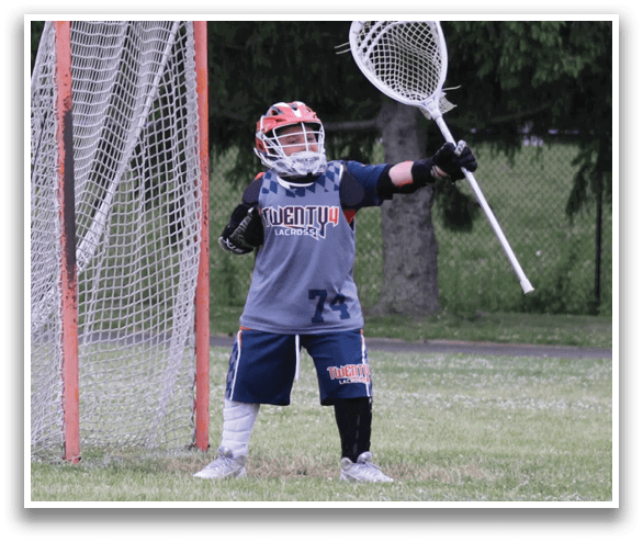 A young boy is standing in a field holding a lacrosse stick, preparing to play. AI generated content