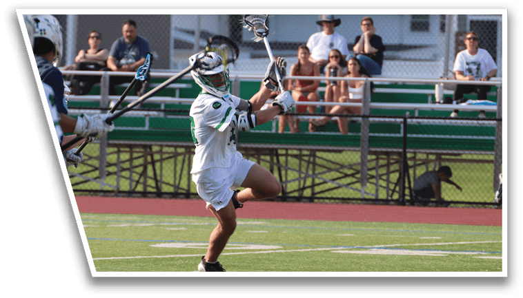 A man in a white uniform is holding a lacrosse stick. Description generated by AI