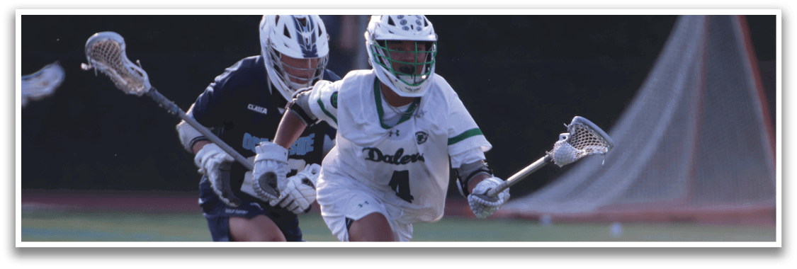 Two men playing lacrosse on a field. Description generated by AI
