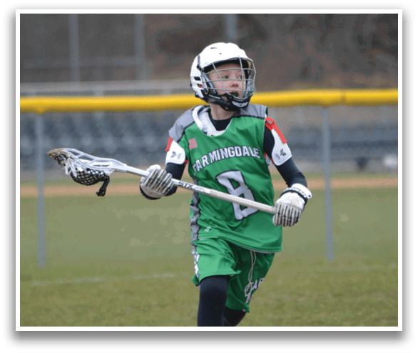 A young boy wearing a green shirt and black shorts is holding a baseball bat and standing on a field. AI generated content