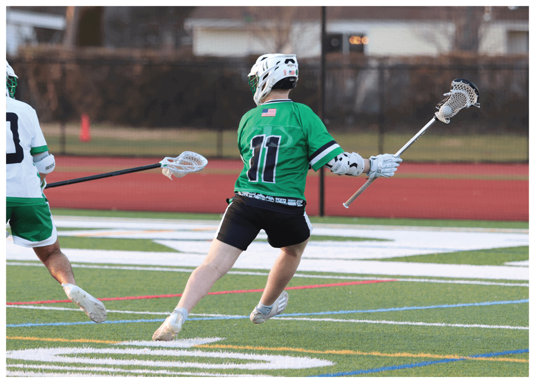 A man in a green jersey is running on a field. Description generated by AI