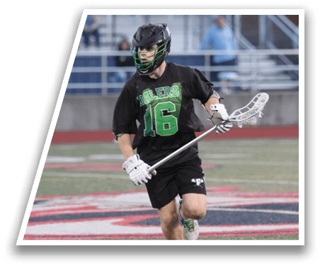 A man wearing a black and green jersey is holding a lacrosse stick. Description generated by AI