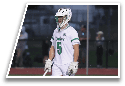 A person wearing a white and green jersey and holding a white and black baseball bat. Description generated by AI