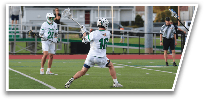 A man in a white uniform is holding a lacrosse stick and preparing to shoot the ball. Description generated by AI