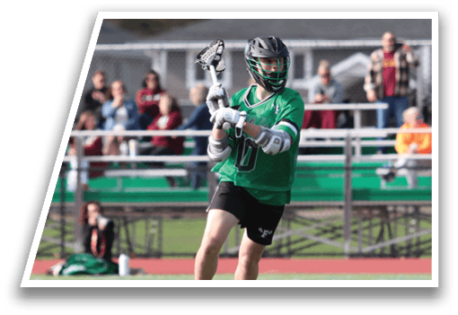A man in a green shirt and black shorts holding a lacrosse stick. Description generated by AI