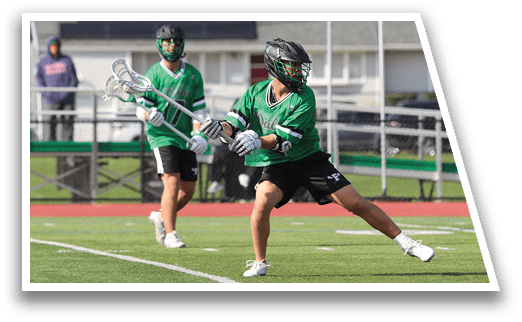 Two men playing lacrosse on a field. Description generated by AI