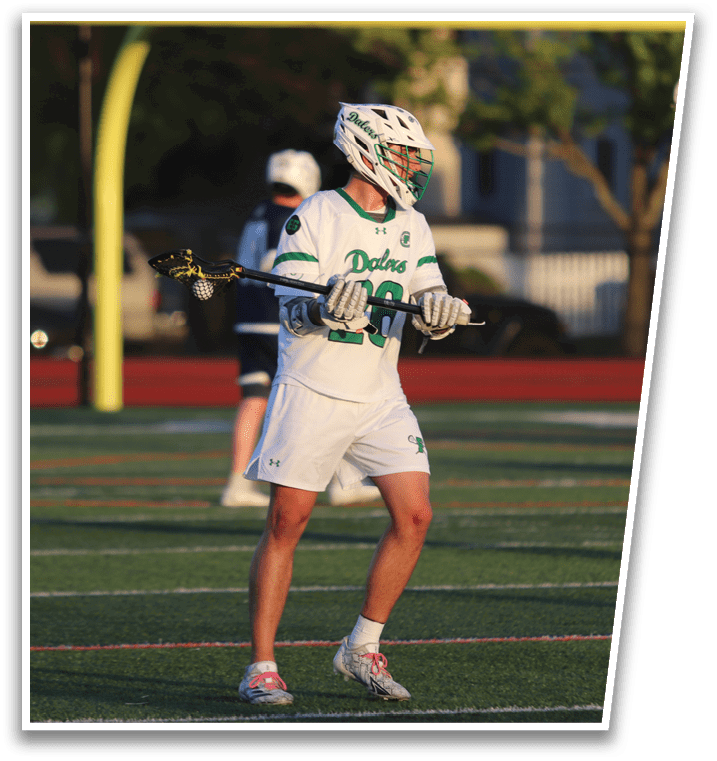 A man wearing a white uniform with a green stripe on his shorts. Description generated by AI