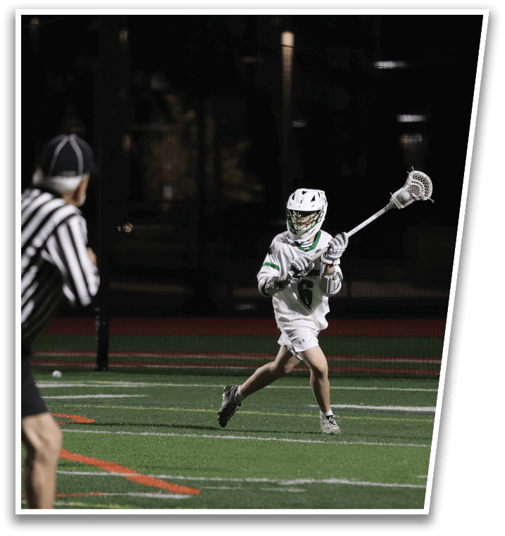 A man in a green and white uniform is holding a lacrosse stick. Description generated by AI