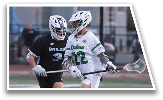 Two men playing lacrosse on a field. Description generated by AI