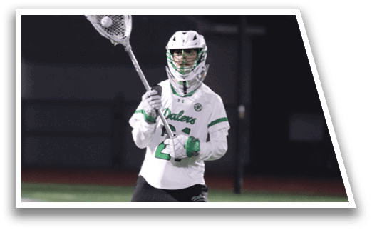 A man holding a lacrosse stick. Description generated by AI