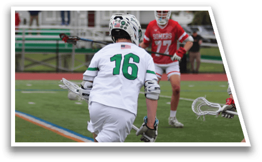 A man wearing a green and white jersey is running with a lacrosse stick. Description generated by AI