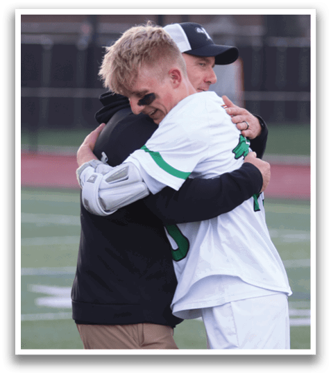 Two men hugging on a field. Description generated by AI