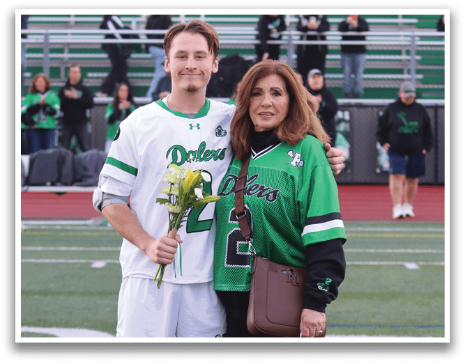 A man and woman standing on a field with a bouquet of flowers. Description generated by AI