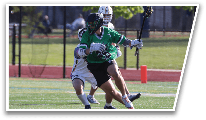 Two men playing lacrosse on a field. Description generated by AI