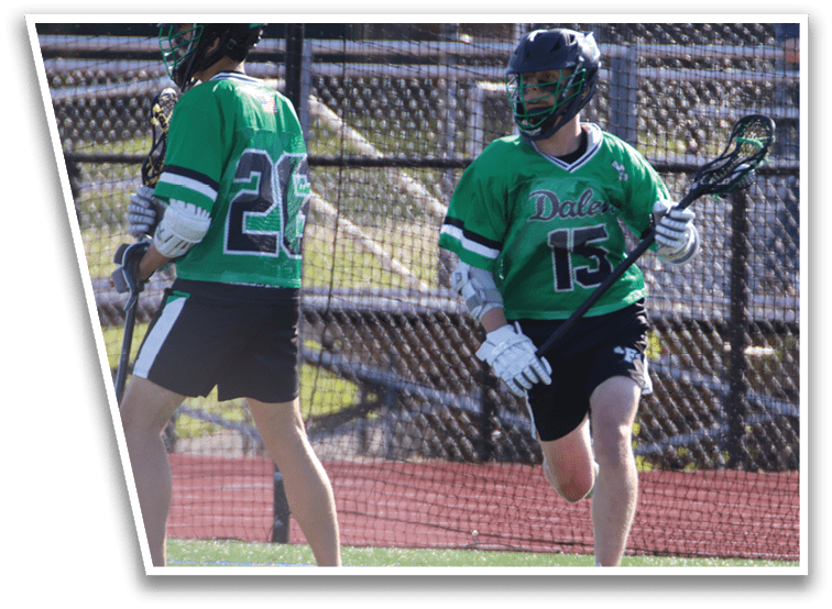 Two people playing lacrosse on a field. Description generated by AI