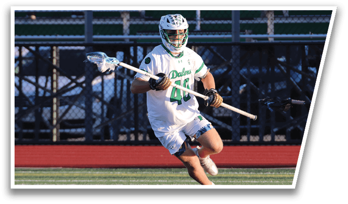 A man wearing a white shirt and green shorts is running on a field. Description generated by AI