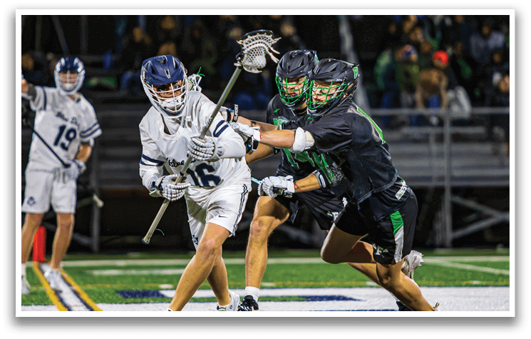 Two men are playing lacrosse on a field. One player is holding a stick and trying to get past the other player who is trying to block him. AI generated content