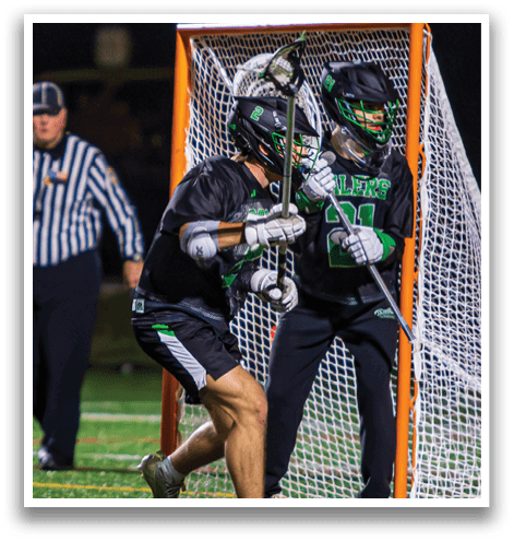 Two men are playing a game of lacrosse, with one of them attempting to score a goal by getting past the goalie. AI generated content