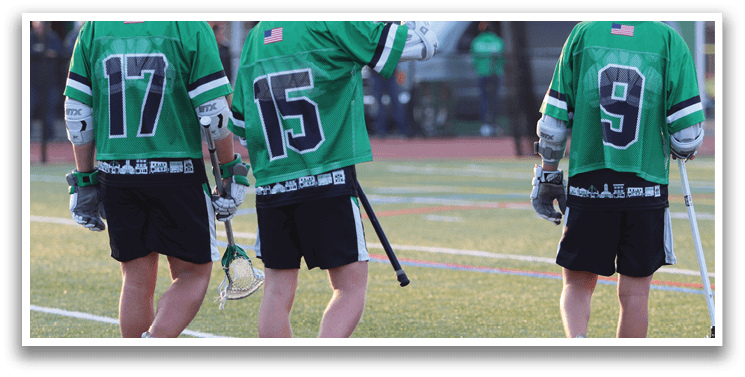 Three men wearing green jerseys and black shorts. Description generated by AI