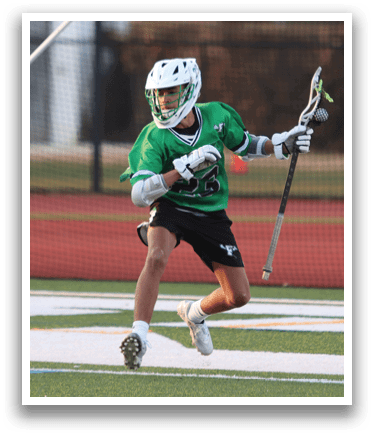 Two boys playing lacrosse on a field. Description generated by AI