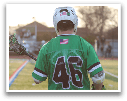 A man wearing a green and white jersey with the number 46 on it. Description generated by AI
