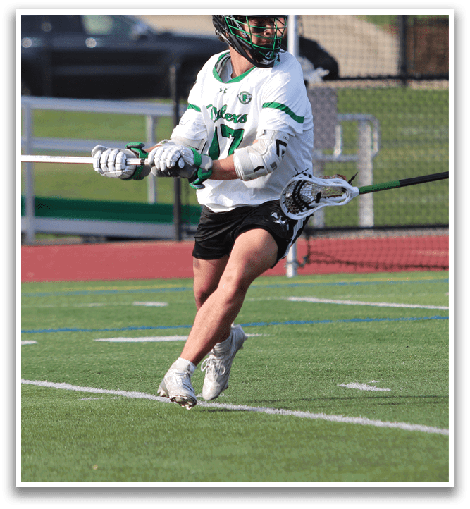 A man is playing lacrosse on a field. Description generated by AI