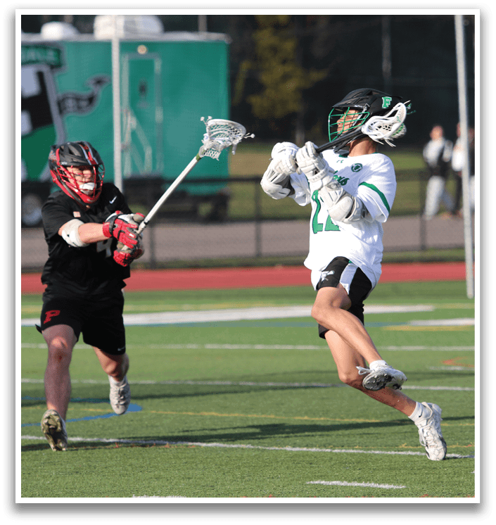 A man in a white shirt and black shorts is holding a lacrosse stick. Description generated by AI