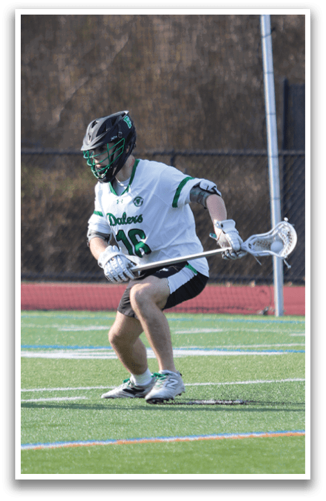 A man is playing lacrosse on a field. Description generated by AI