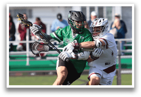 Two men playing lacrosse on a field. Description generated by AI