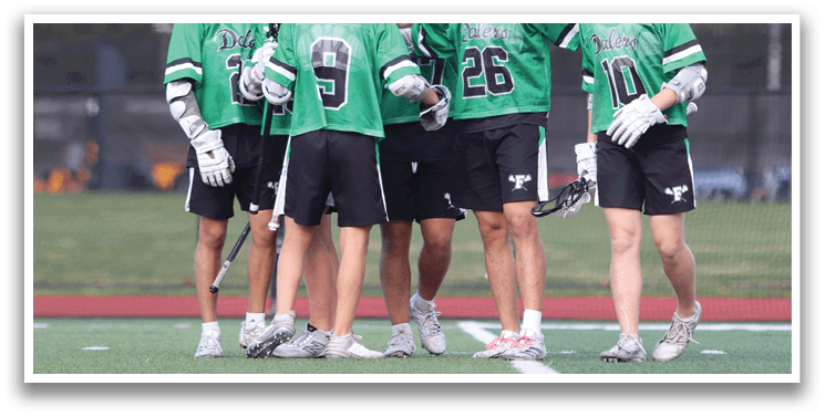 A group of young men wearing green and black uniforms. Description generated by AI