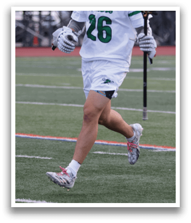 A man wearing a white shirt and green shorts is running on a field. Description generated by AI