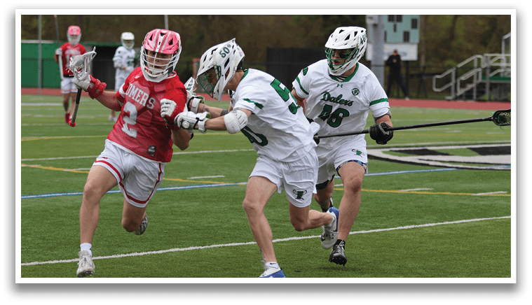 Two men playing lacrosse on a field. Description generated by AI