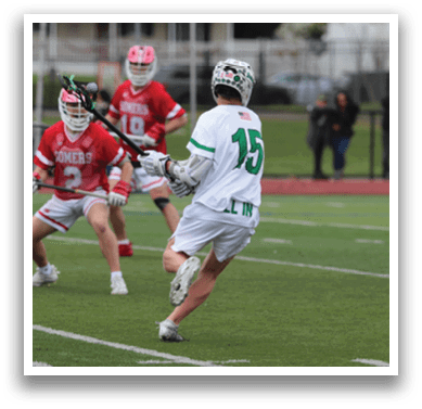 A group of people playing lacrosse on a field. Description generated by AI