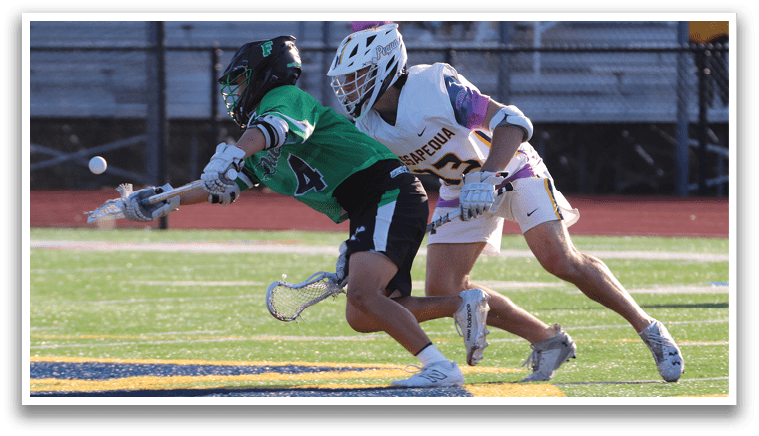 Two men playing lacrosse on a field. Description generated by AI