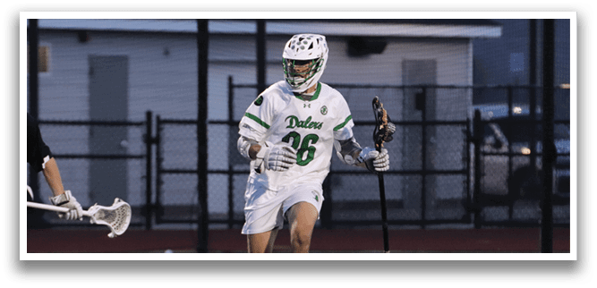 A man wearing a white and green jersey is running on a field. Description generated by AI