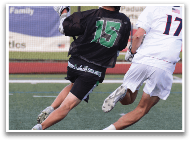 Two men playing a game of lacrosse. Description generated by AI