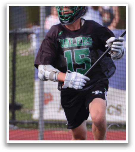 A man wearing a black and green jersey is running on a field. Description generated by AI