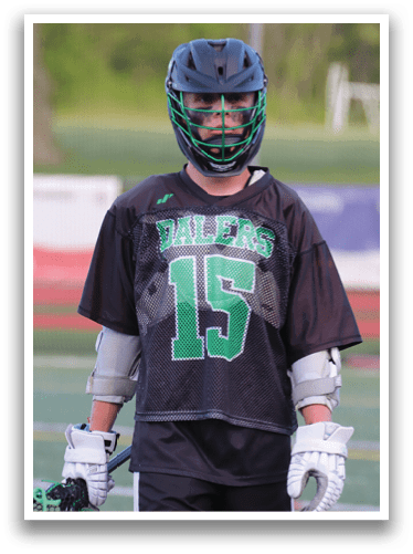 A boy wearing a black and green jersey with the number 15 on it. Description generated by AI