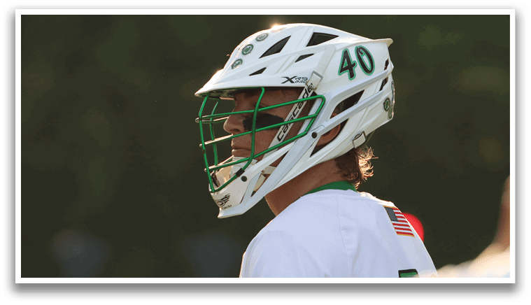Two men playing lacrosse on a field. Description generated by AI