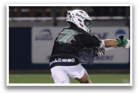 A man wearing a white shirt and green shorts is running on a field. Description generated by AI