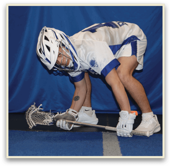 A man wearing a helmet and kneeling down with a lacrosse stick. AI generated content