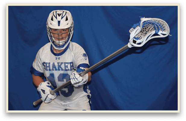 A young man wearing a white and blue jersey holds a lacrosse stick. AI generated content
