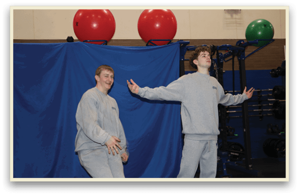 Two men in grey sweatshirts are standing in a gym. AI generated content