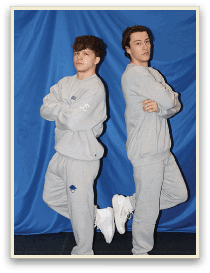 Two young men wearing gray sweatsuits pose for a picture. AI generated content
