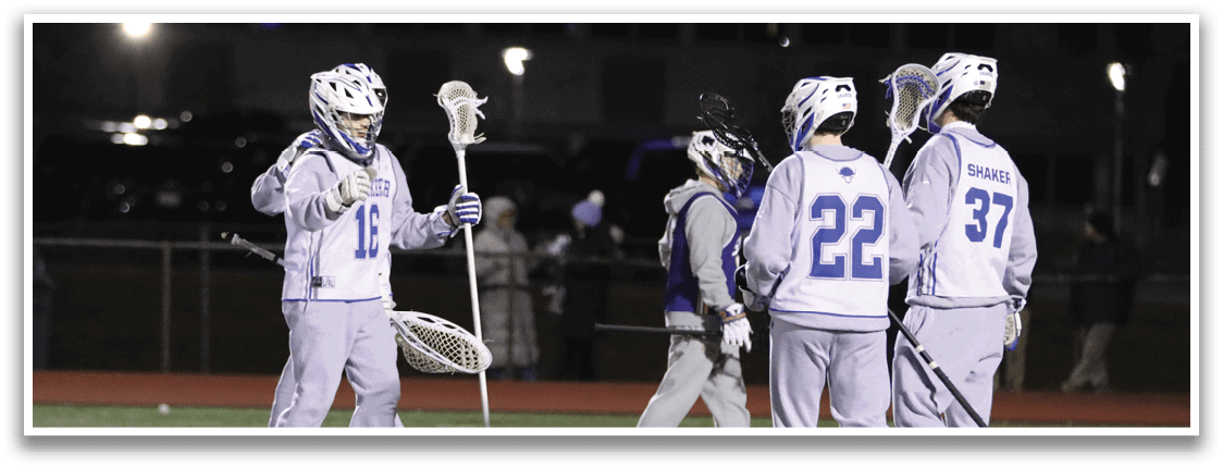 A group of young men playing lacrosse on a field at night. AI generated content