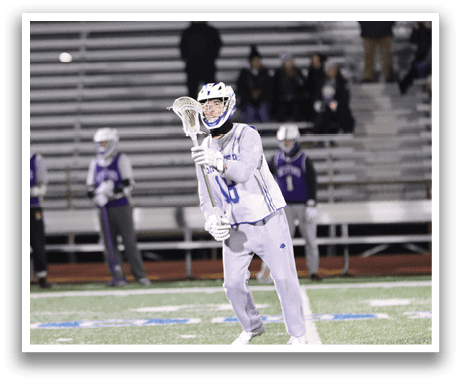 A man in a grey uniform holding a lacrosse stick on a field. AI generated content