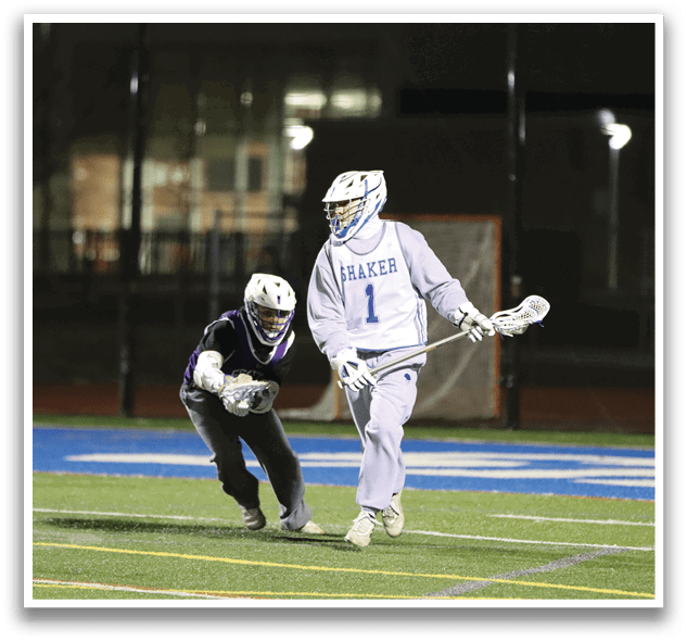 Two men playing a game of lacrosse on a field at night. AI generated content