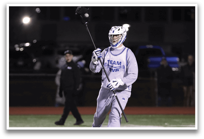 A man in a grey uniform is holding a black and white stick while standing on a field. AI generated content