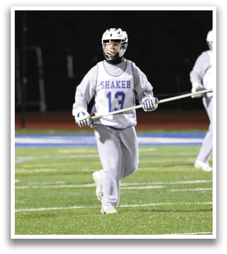 A group of lacrosse players on a field, one of them holding a stick. AI generated content